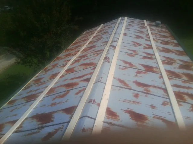 Rusted metal roof panels with new wood purlins before replacement — Storm Damage Roof Repair in South New Berlin by Roofing Brothers