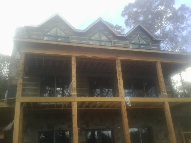 Dormers and porch framing on a large log home under construction — Roof Coating work by our crew in South New Berlin