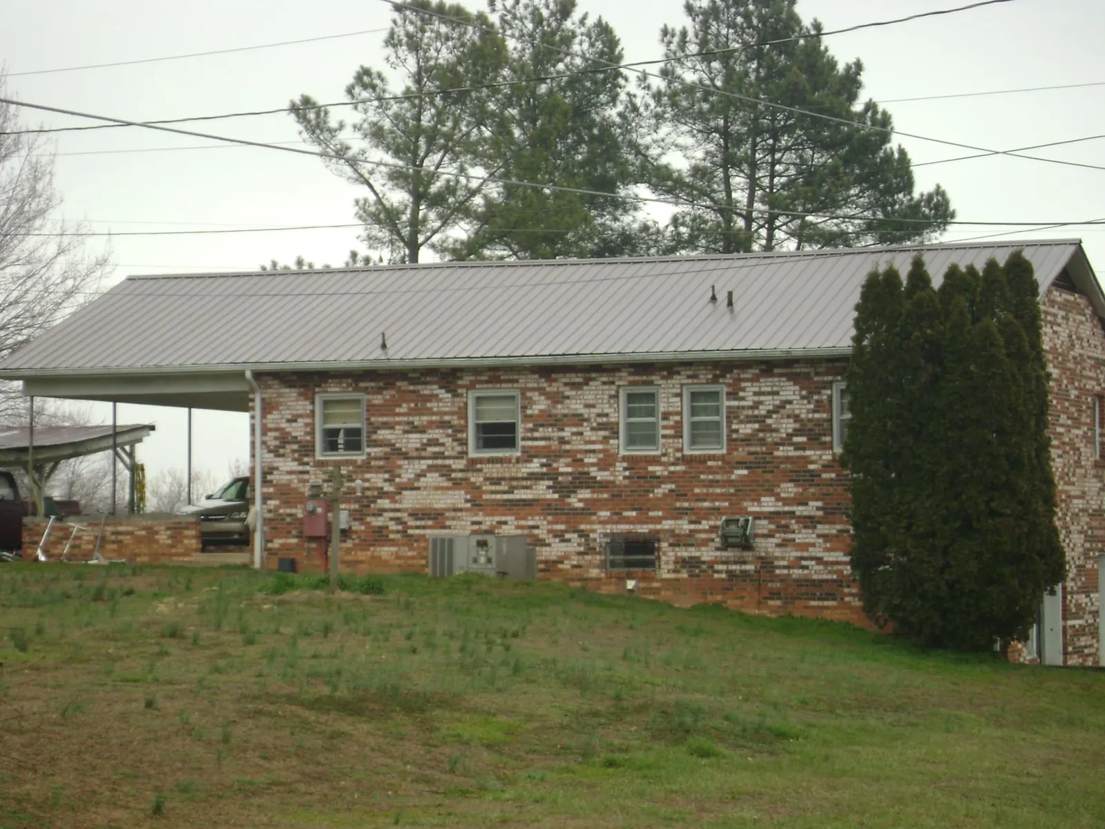 Gray metal roof on a brick split level home with a carport in South New Berlin