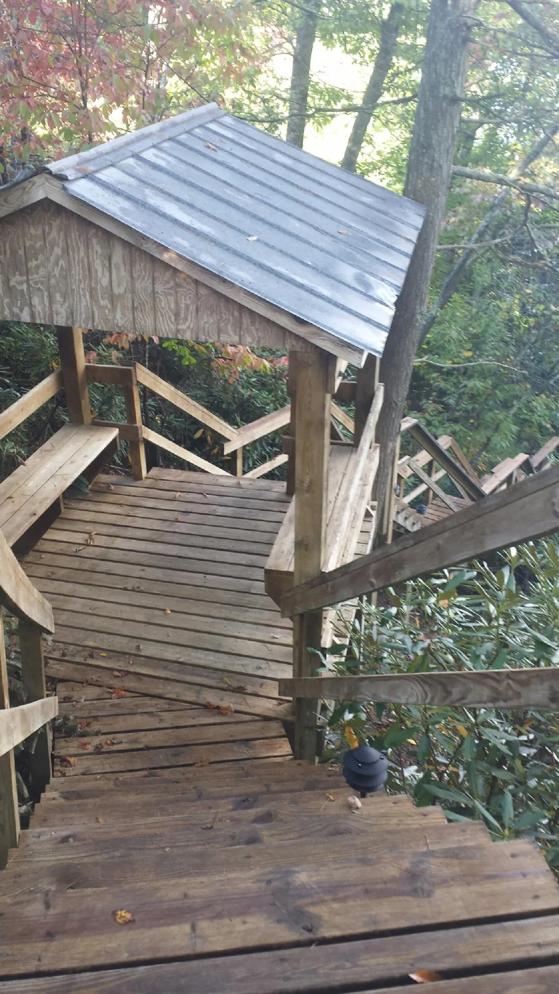 Metal roofed shelter over wooden steps on a wooded walkway — Skylight Repair & Installation work by our crew in South New Berlin