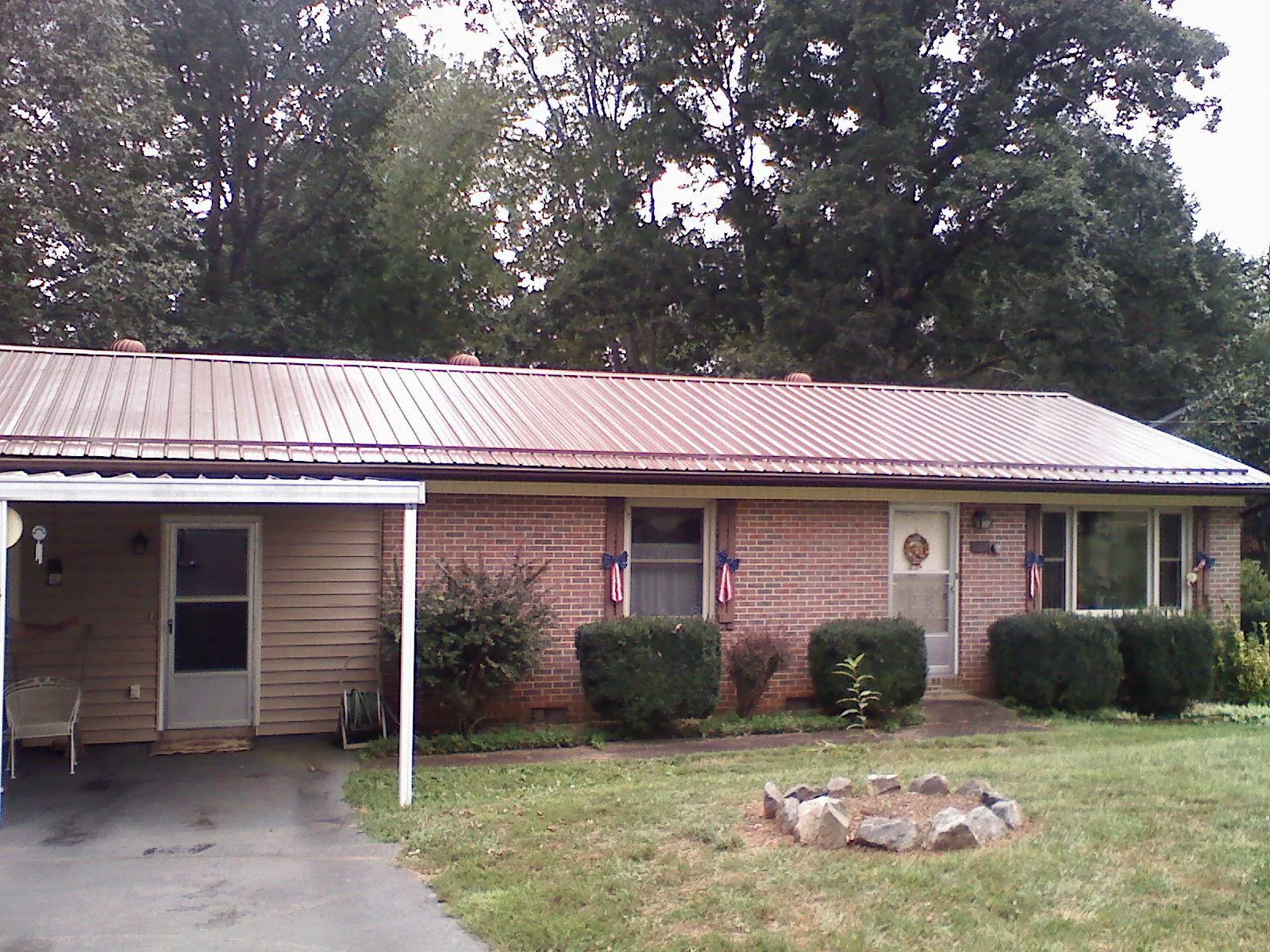 Bronze metal roof and carport on a brick ranch home — Roof Repair work by our crew in South New Berlin